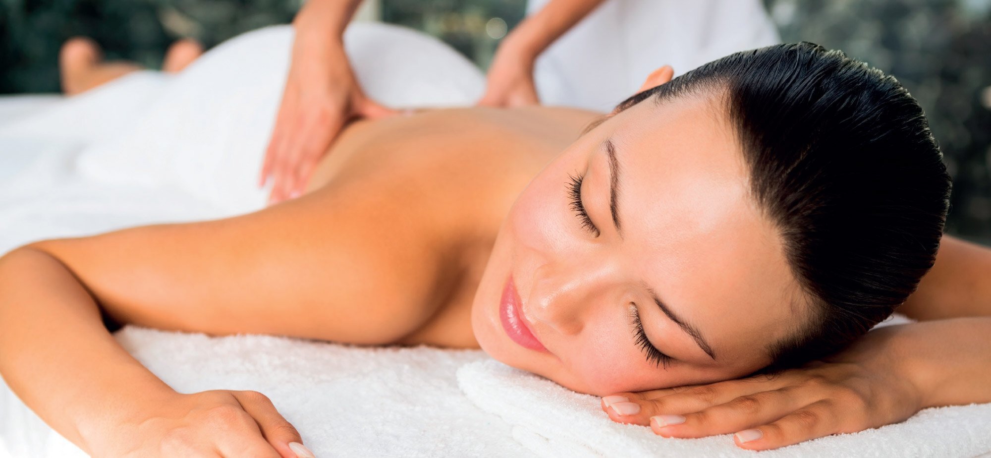 Frau genießt eine Massage in Hamburg am unteren Rücken im Grand Elysee Spa