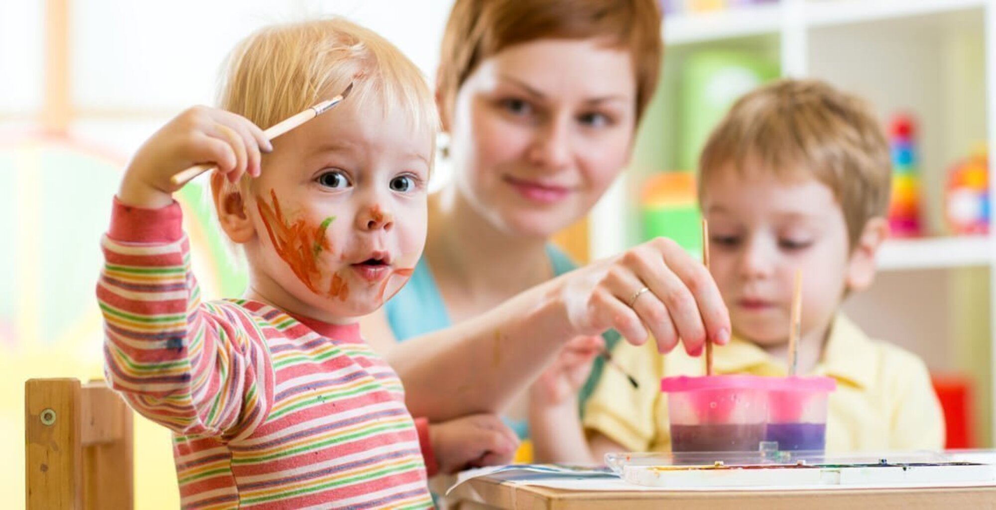 Kindergartenbetreuering mal mit zwei Kindern mit Wasserfarben im Grand Elysée Hamburg