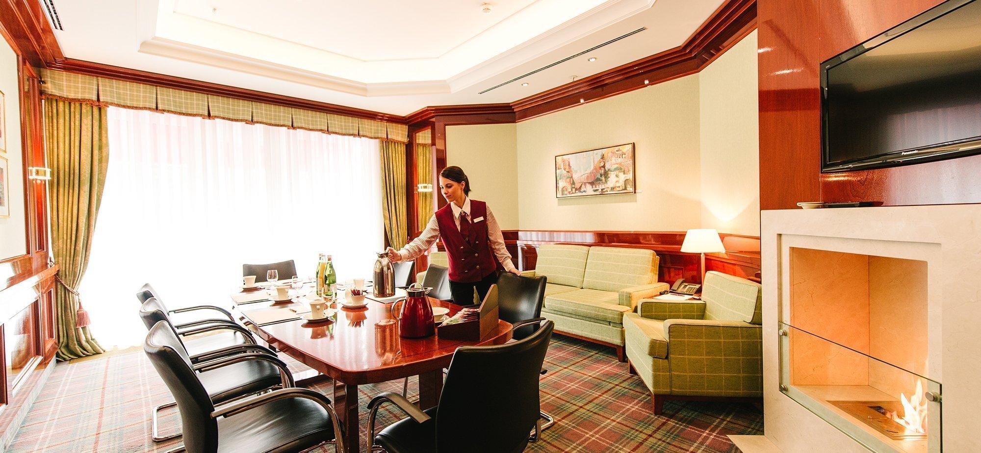 Hotelangestellte stellt den Kaffee auf den Konferenztisch