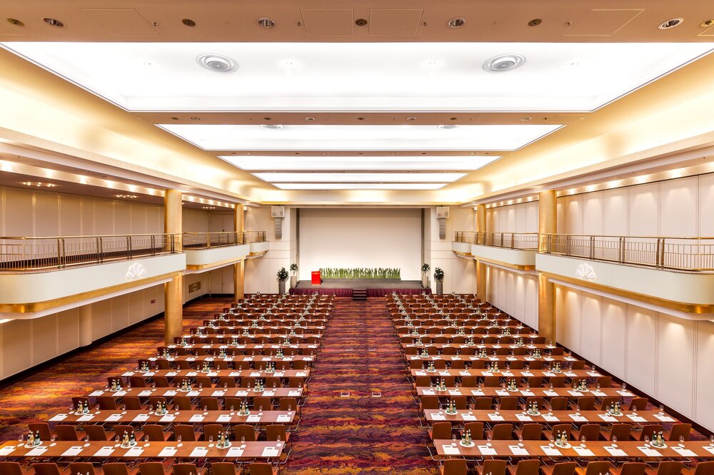 Rießiger Konferenzsaal mit Leinwand und Bühne für einen Speaker