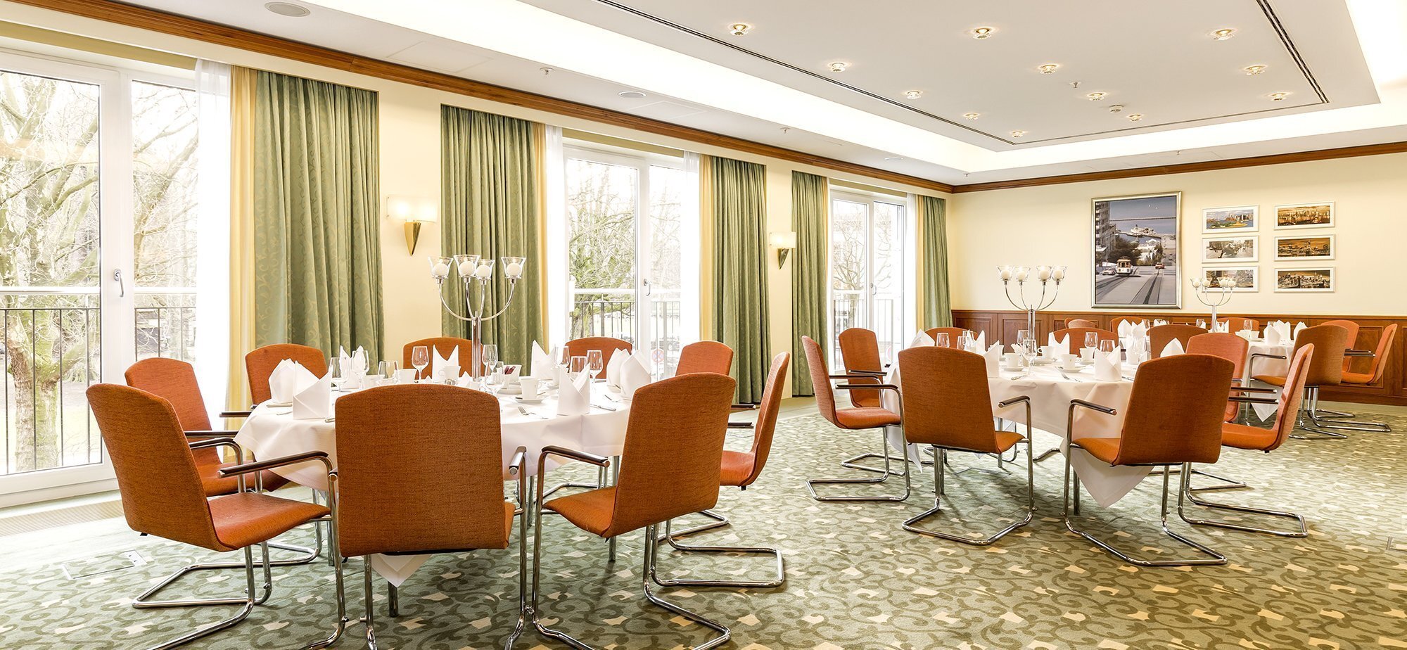 Drei runde Tische mit Besteck und Kerzenleuchtern im Grand Elysee