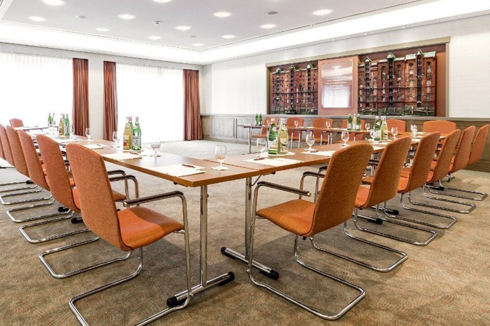Heller Seminarraum "Speicherstadt" des Grand Elysée Hotels in Hamburg mit diversen Plätzen und vorbereiteten Getränken